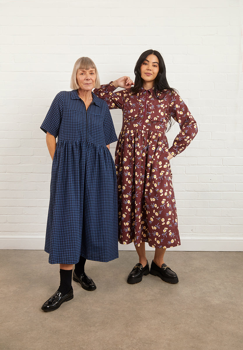 Women wearing the Aspen Dress sewing pattern from Fabric Godmother on The Fold Line. A shirt dress pattern made in cotton, linen, or denim fabric, featuring a collar and stand, exposed zip front opening, long or short sleeves, patch pockets with an optional ruffle, gathered skirt, and midi length.
