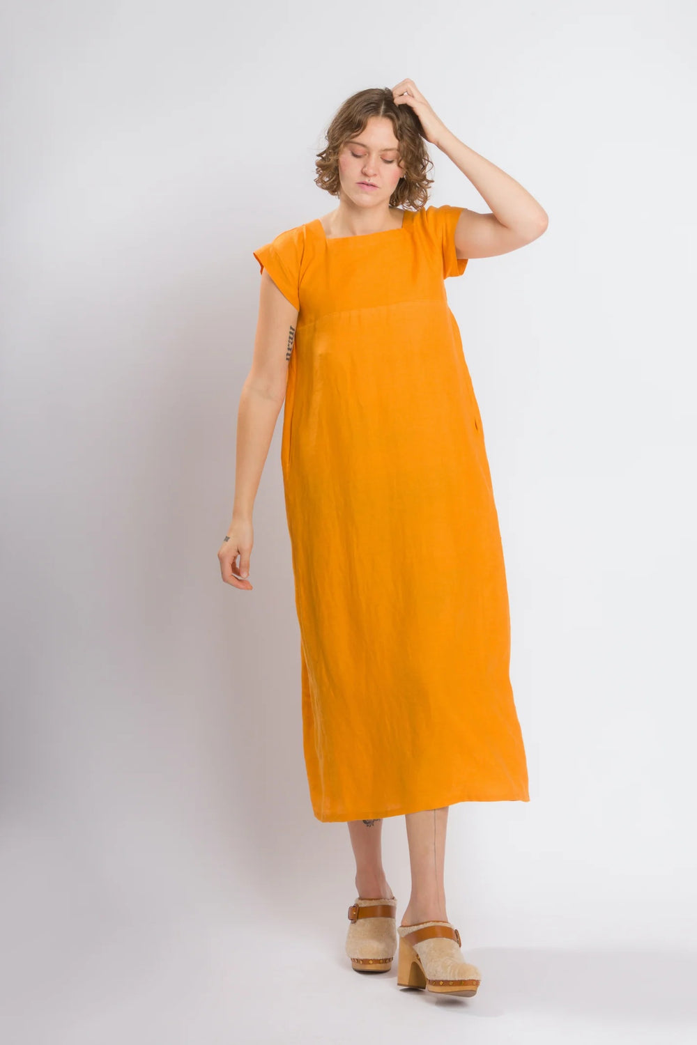 Woman wearing the Casita Dress sewing pattern from 奥州五开奖官网开奖号 Cris Wood Sews on The Fold Line. A dress pattern made in linen, lightweight cotton, silk, rayon, viscose blend, or gauze fabric, featuring a square neckline, front and back yokes, short grown-on sleeves, side seam pockets, and a midi length.