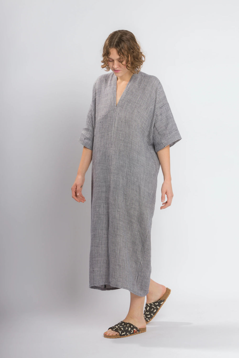 Woman wearing the Envelope Dress Hack Pack sewing pattern from Cris Wood Sews on The Fold Line. A dress pattern made in linen, rayon, silk, viscose blend, or lightweight cotton fabric, featuring a relaxed fit, deep v-neckline, mid-length sleeves, and midi length.