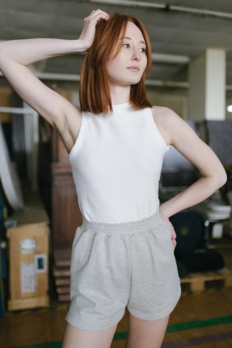 Woman wearing the Kaya Shorts sewing pattern from JULIANA MARTEJEVS on The Fold Line. A shorts pattern made in sweat fabric with stretch, featuring an elastic waist, side pockets, and side slits.