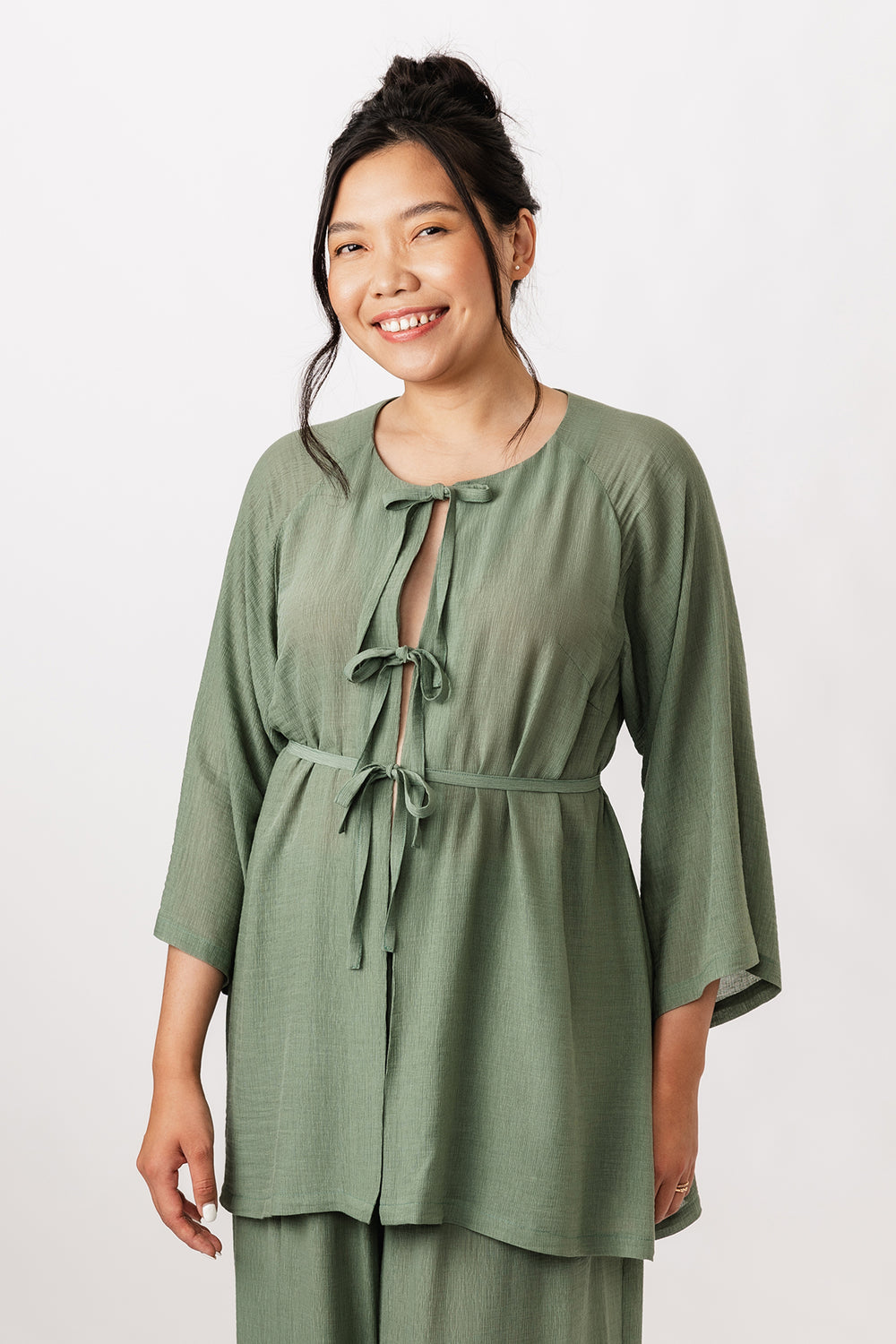 Woman wearing the Maite Raglan Tunic sewing pattern from Named on The Fold Line. A top pattern made in viscose challis or crepe, cotton lawn, or washed linen fabric, featuring a round neck, 3/4-length raglan sleeves, thin belt, and front tie fastenings.