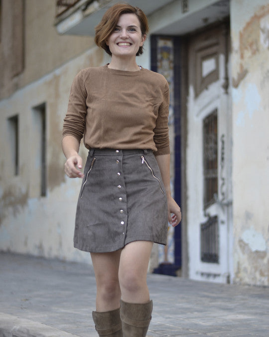 Woman wearing the Rosarí Skirt sewing pattern from Pauline Alice on The Fold Line. A skirt pattern made in cotton, corduroy, gabardine, linen, denim, or suede fabric, featuring a button front, zipped front pockets, and mini length.