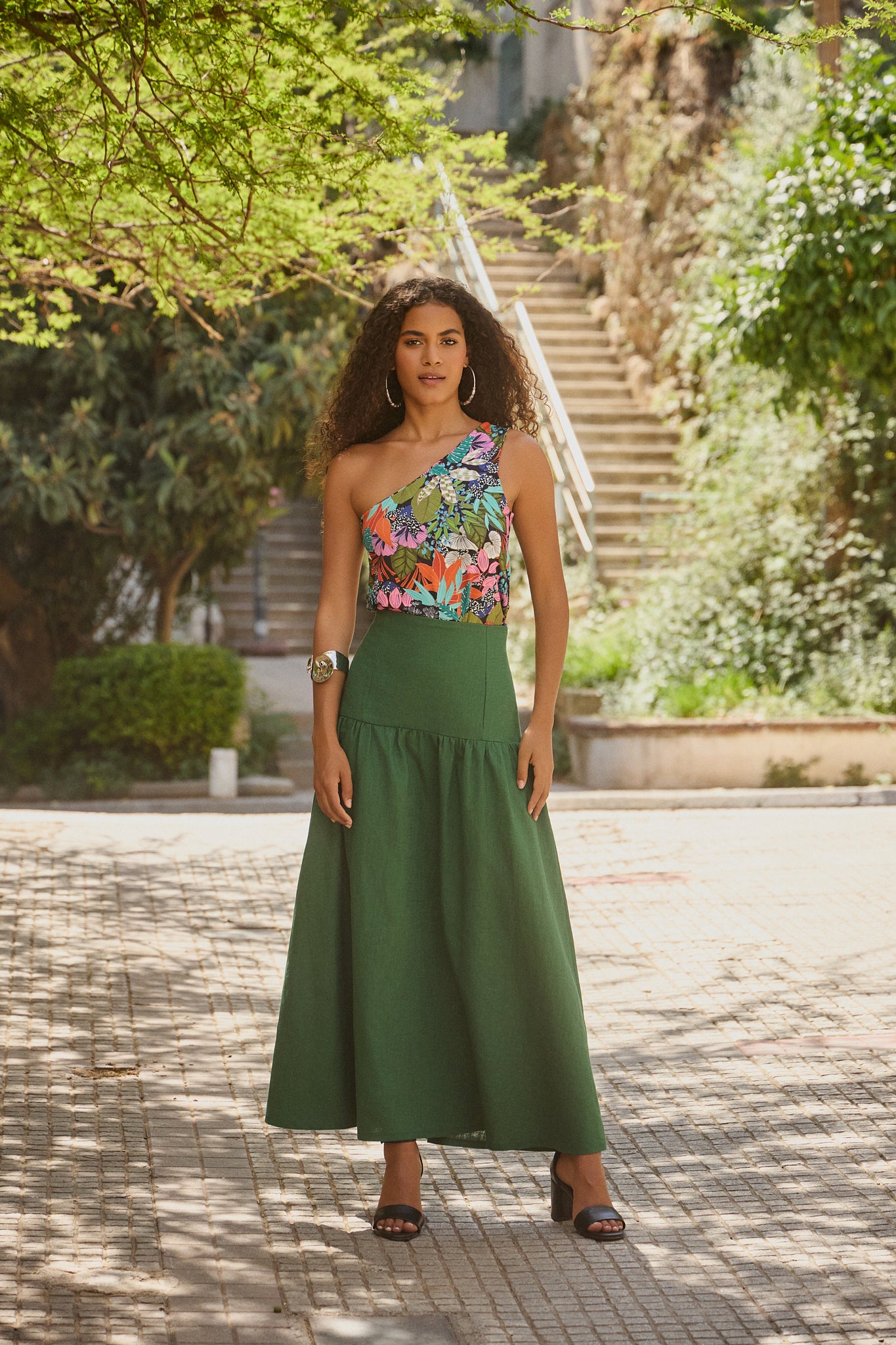 Woman wearing the Tina Skirt sewing pattern from The Patterns Room on The Fold Line. A skirt pattern made in linen, viscose crepe, lyocell, or wool fabric, featuring a fitted yoke, gathered tier, and maxi length.