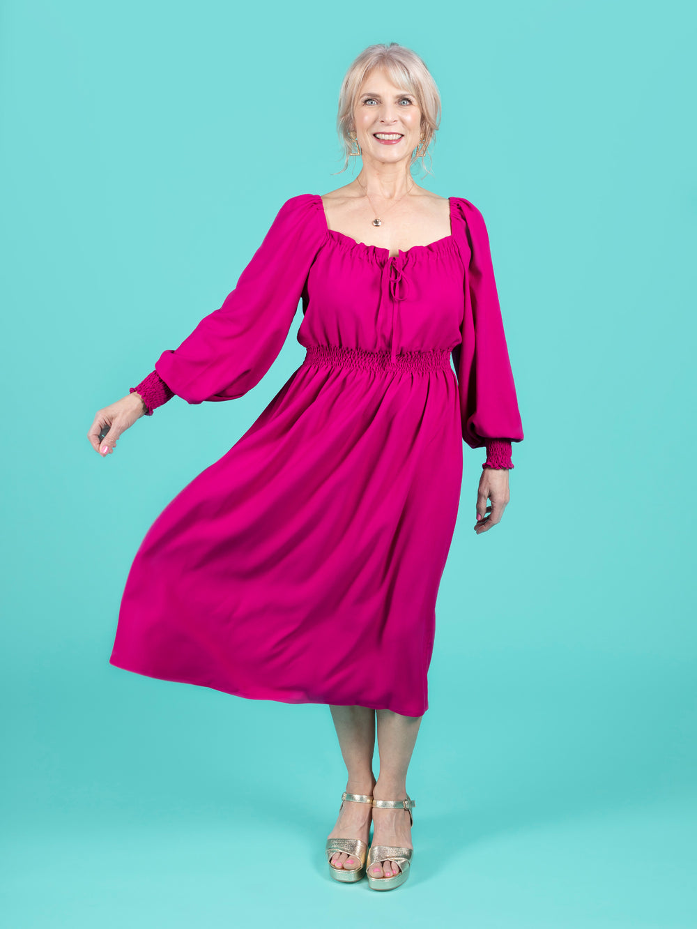 Woman wearing the Mabel Dress sewing pattern from Tilly and the Buttons on The Fold Line. A dress pattern made in cotton lawn, poplin, voile, seersucker, viscose (rayon) or crêpe fabrics, featuring a shirred waist, full skirt, square elasticated neckline 